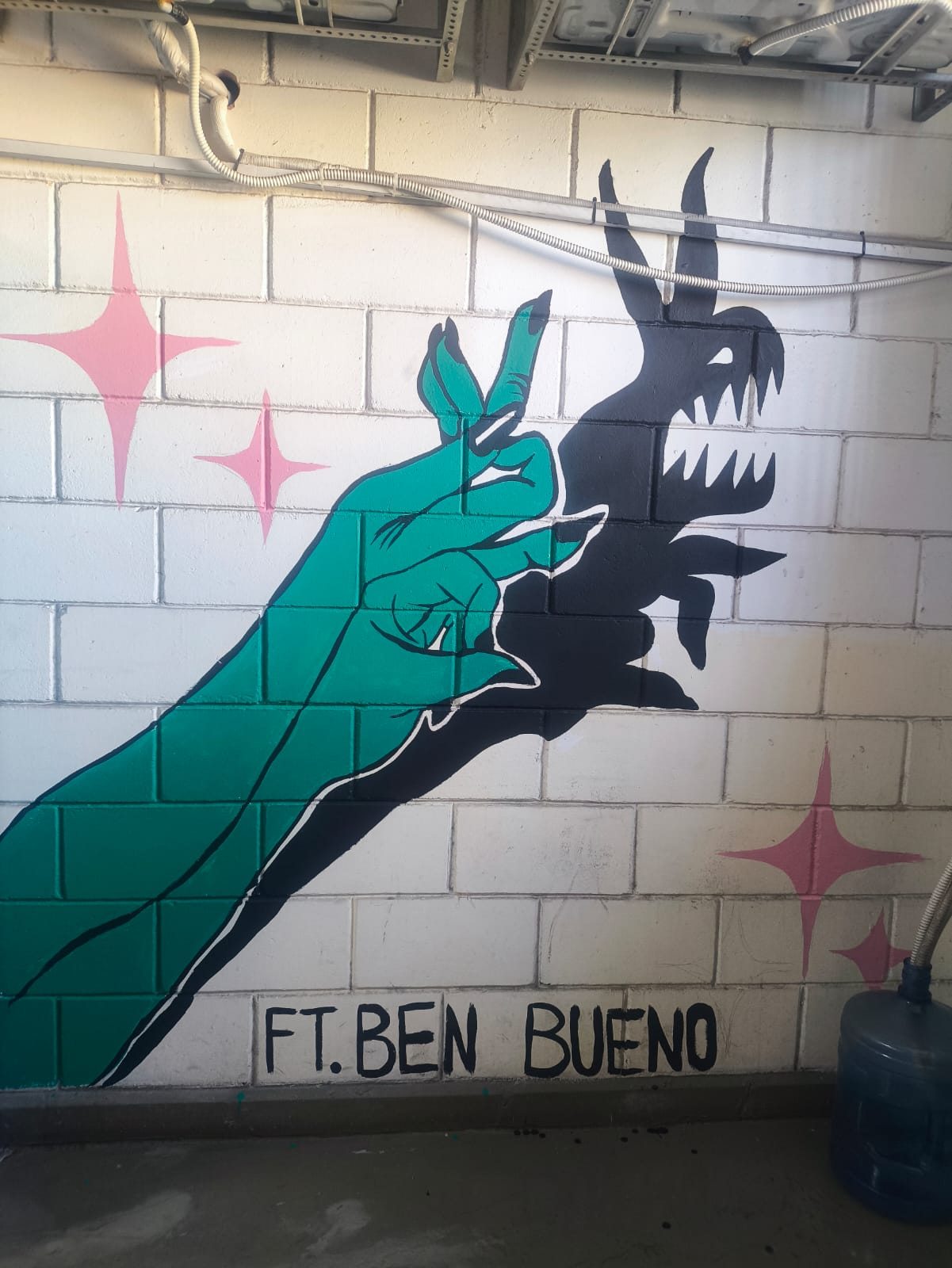 ציור קיר של יד ירוקה שמטילה צל של דרקון, חתום Ben Bueno