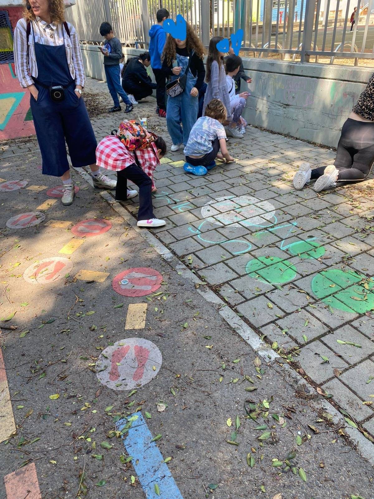 ילדים מציירים בגיר על המדרכה בסוף הסיור